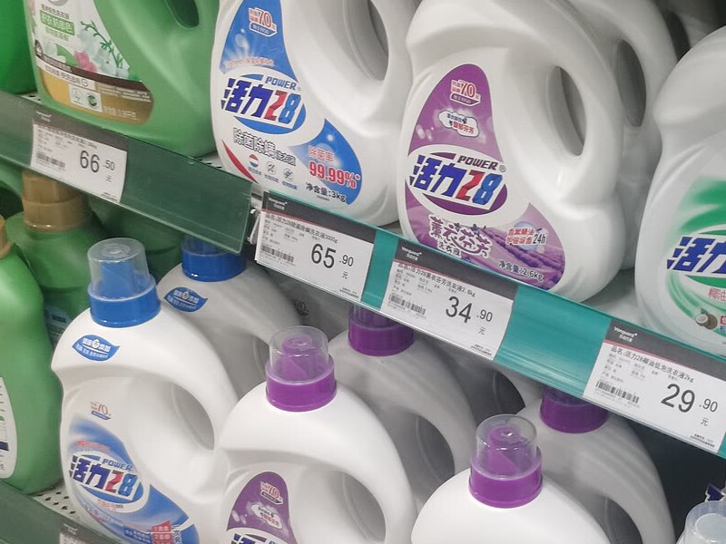 Shelf of liquid laundry detergent bottles in a Chinese supermarket